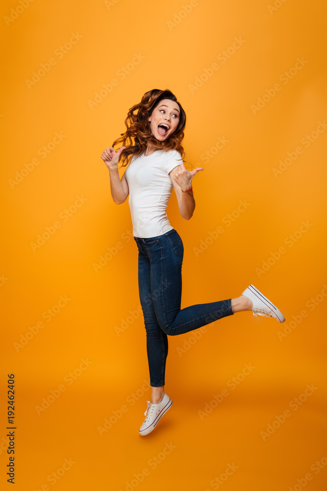 Full length image of Happy brunette woman in t-shirt jumping Full length image of Happy brunette woman in t-shirt jumping