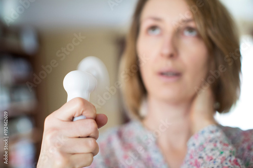 Mature Woman Experiencing Hot Flush From Menopause Using Electric Fan photo