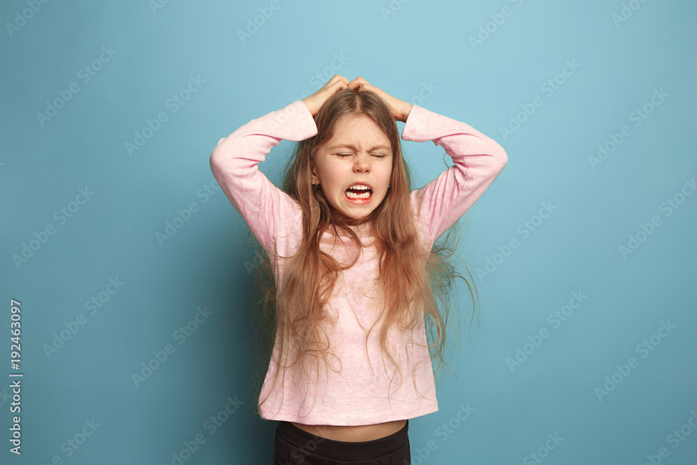 The cry. Teen girl on a blue background. Facial expressions and people emotions concept The cry. Teen girl on a blue background. Facial expressions and people emotions concept