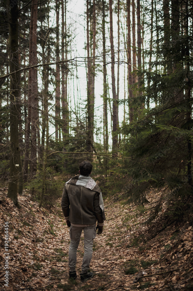 Man in woods walking alone and looking forward