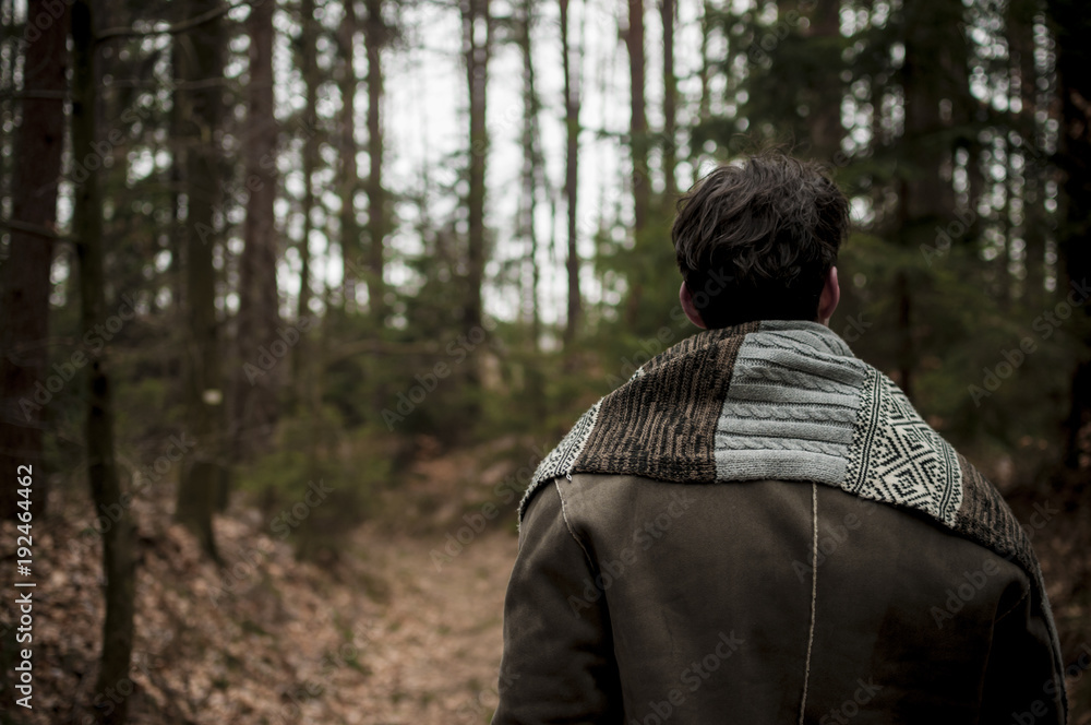 Man in woods walking alone and looking forward Man in woods walking alone and looking forward