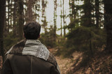 Man in woods walking alone and looking forward