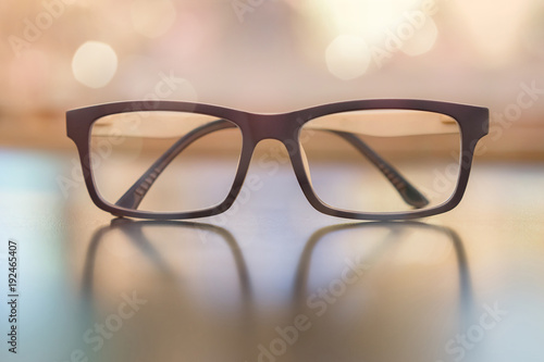 Pastel eye glasses on wood background with bokeh.