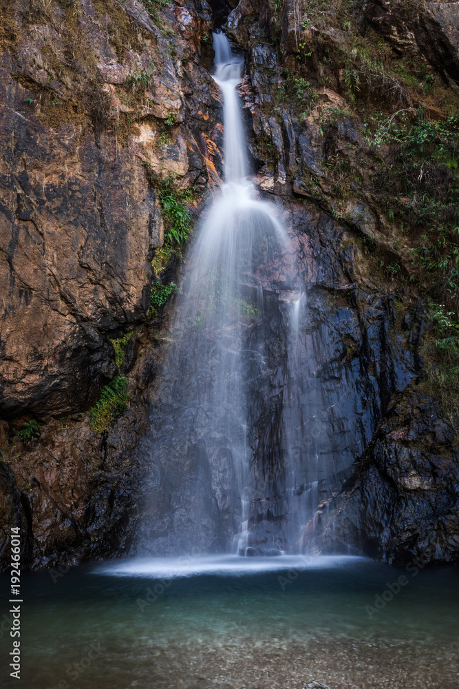 Fototapeta premium Jokkradin waterfall with rock cliff in Kanchanaburi, Thailand