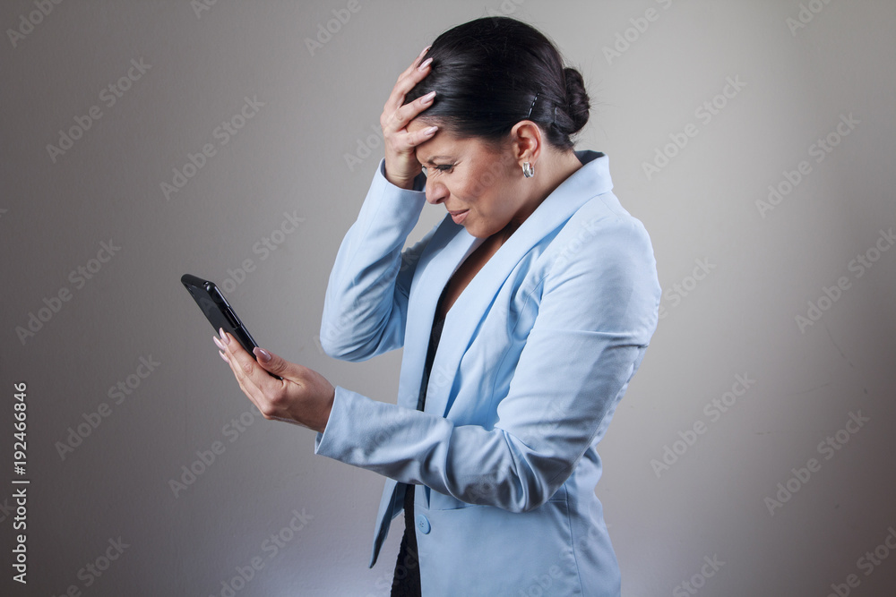 Young corporate business woman shocked with a message she receives on her cell phone Young corporate business woman shocked with a message she receives on her cell phone