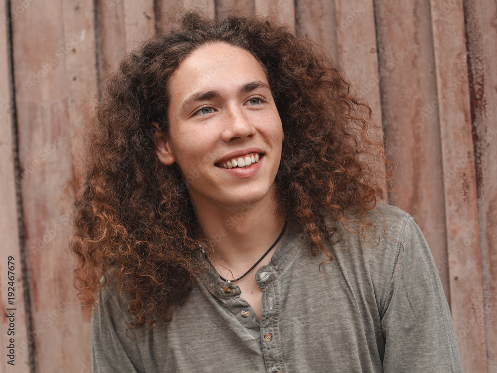 A nice young man is posing near wooden background A nice young man is posing near wooden background