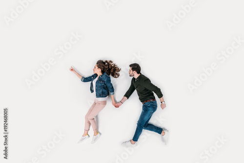 top view of couple walking and holding hands isolated on white