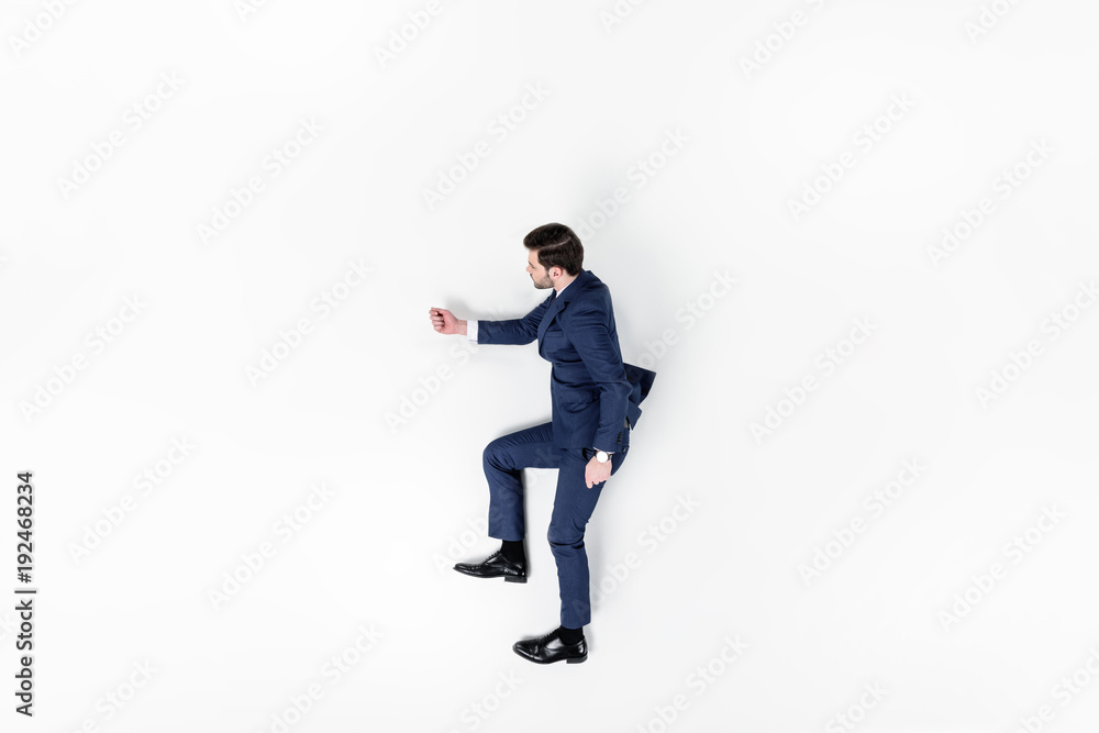 top view of young businessman pretending to walk upstairs isolated on white top view of young businessman pretending to walk upstairs isolated on white