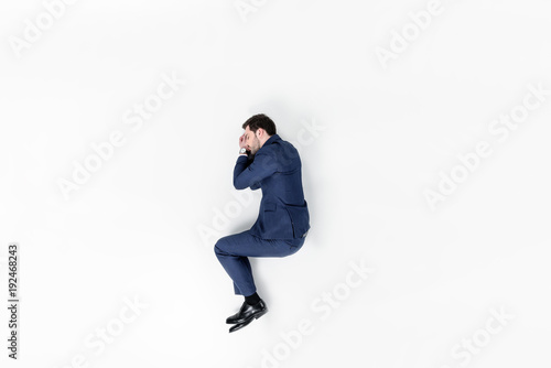 top view of young businessman sleeping in suit isolated on white © LIGHTFIELD STUDIOS