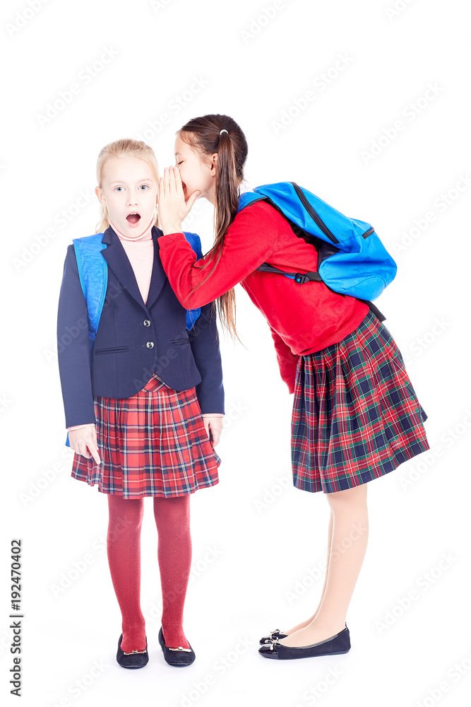 School girlfriends in uniform gossiping on white background School girlfriends in uniform gossiping on white background
