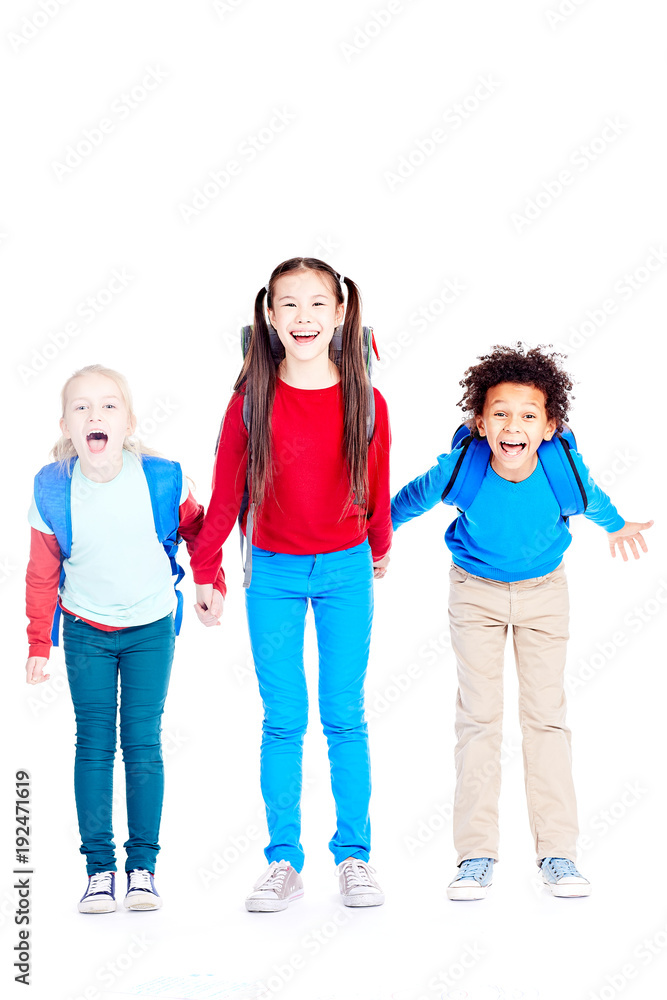 Obraz premium Portrait of three multi-ethnic school friends holding hands on white background