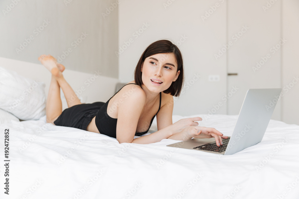 Portrait of a smiling young woman using laptop computer Portrait of a smiling young woman using laptop computer