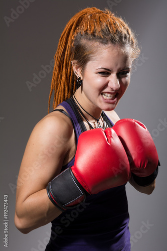 Young woman boxer with dreadlocks with clenched teeth © kanzefar