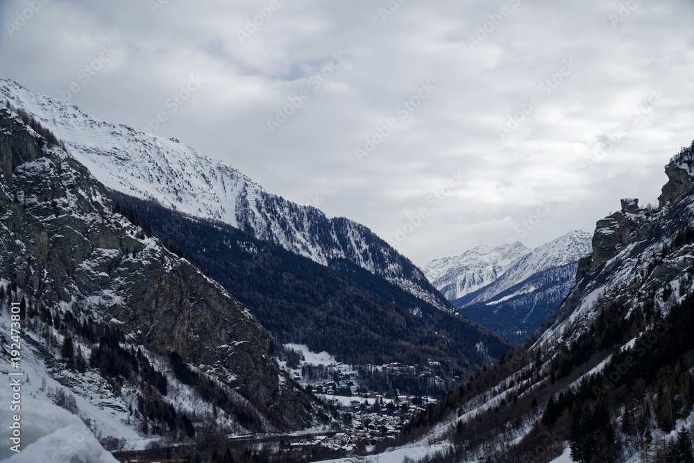 Canyon mountains covered with snow and winter forest near Mont Blanc Alpes, Italy