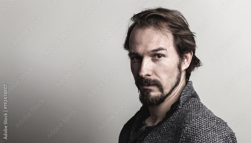 Fototapeta premium Portrait of a handsome serious and casual young man against grey background.