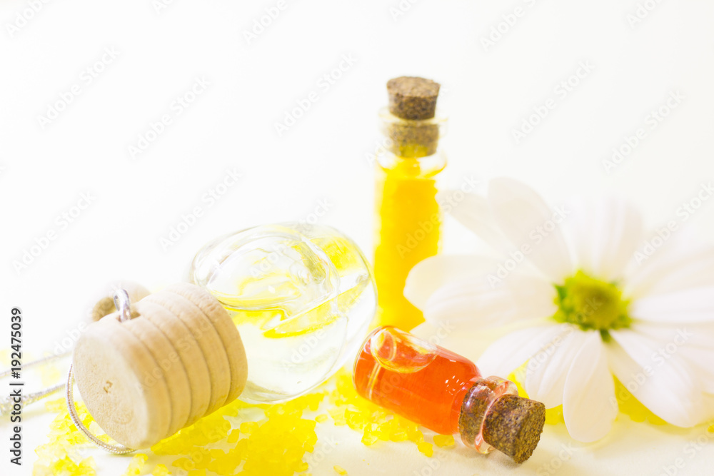 Fruit aromatherapy concept with essential oil in glass bottles, a sea salt on the table, flower, white background, close up Fruit aromatherapy concept with essential oil in glass bottles, a sea salt on the table, flower, white background, close up