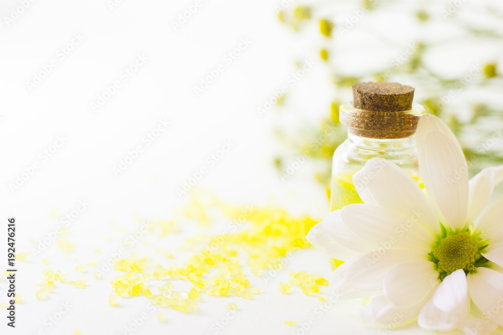 Fruit aromatherapy concept with essential oil in glass bottles, bath sea salt on the table, flowers, white background, close up Fruit aromatherapy concept with essential oil in glass bottles, bath sea salt on the table, flowers, white background, close up