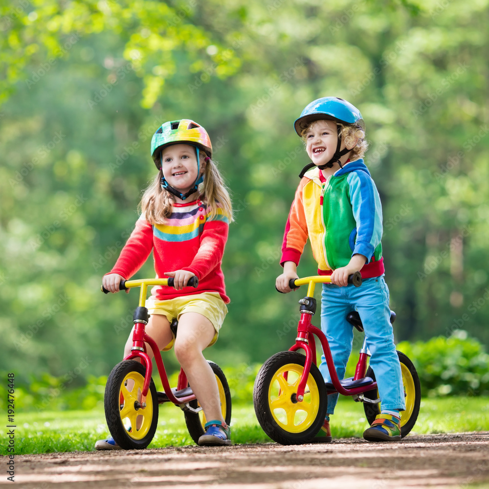 Fototapeta premium Kids ride balance bike in park
