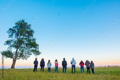 Group friend on mountain of sunsets background.