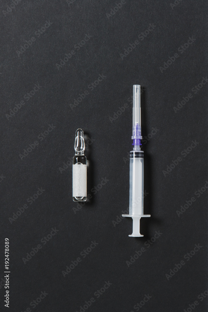 Naklejka premium Medication ampoule, empty syringe needle on black background. Health, treatment, choice, healthy lifestyle concept. Copy space for advertisement. With place for text.