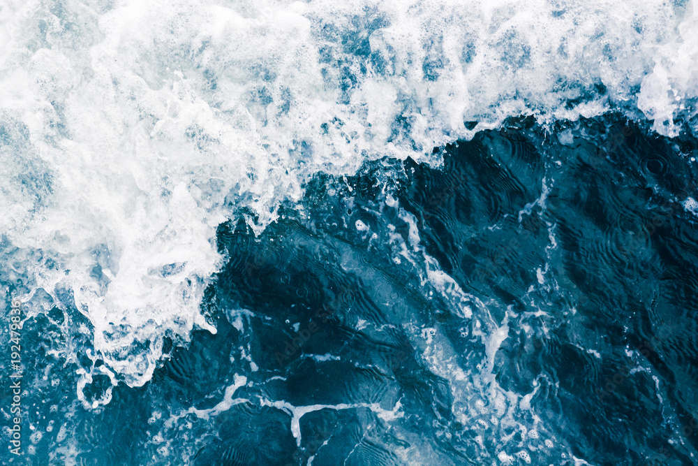 Fototapeta premium The surface of the sea with waves, splash, foam and bubbles, aqua abstract background