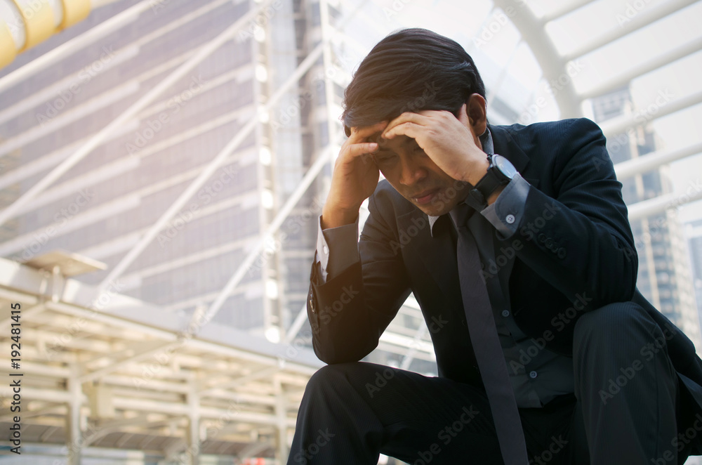Fototapeta premium disappointed, sadness or stressed medium aged unemployed asian business man sitting on the walkway in the city after fired from job, business problem, unemployment, financial and investment concept