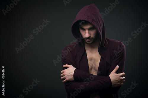 Male fashion model wearing hoodie in studio over grey background