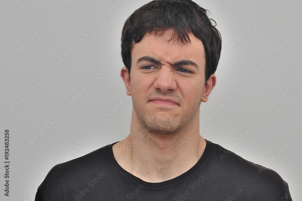 Fototapeta premium portrait of a frowning young man on a white background