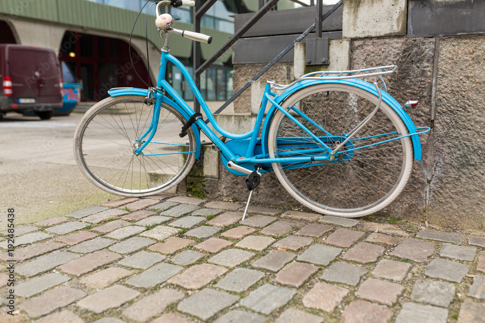 Hellblaues Fahrrad angekettet