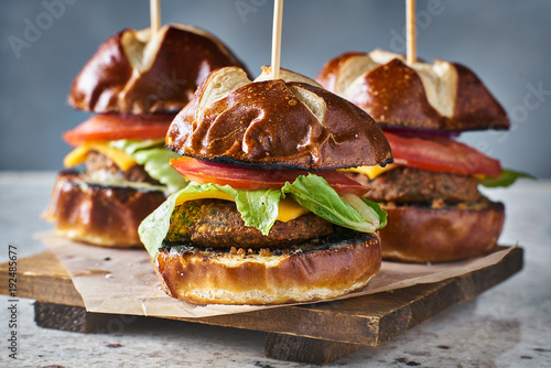 three vegan burger sliders with pretzel buns