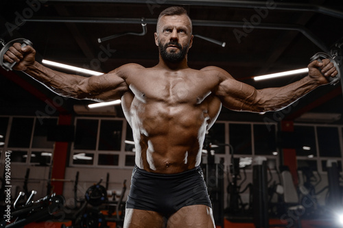 Old brutal strong bodybuilder athletic men pumping up muscles with dumbbells