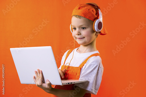 funny boy builder in headphones and laptop doing repairs on bright background