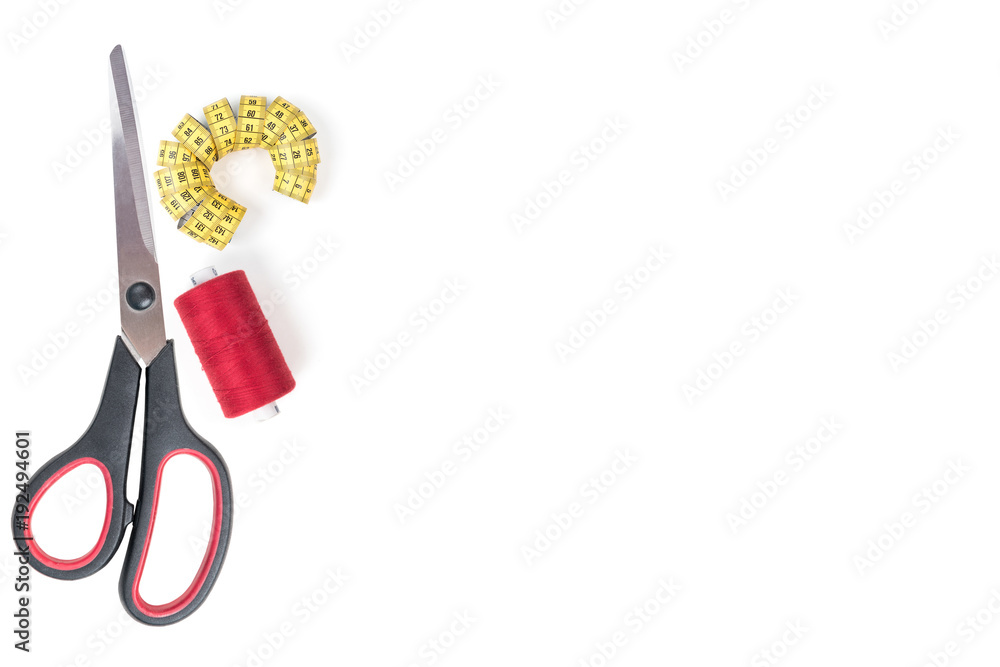 Sewing accessories and tools. Red sewing threads, black scissors