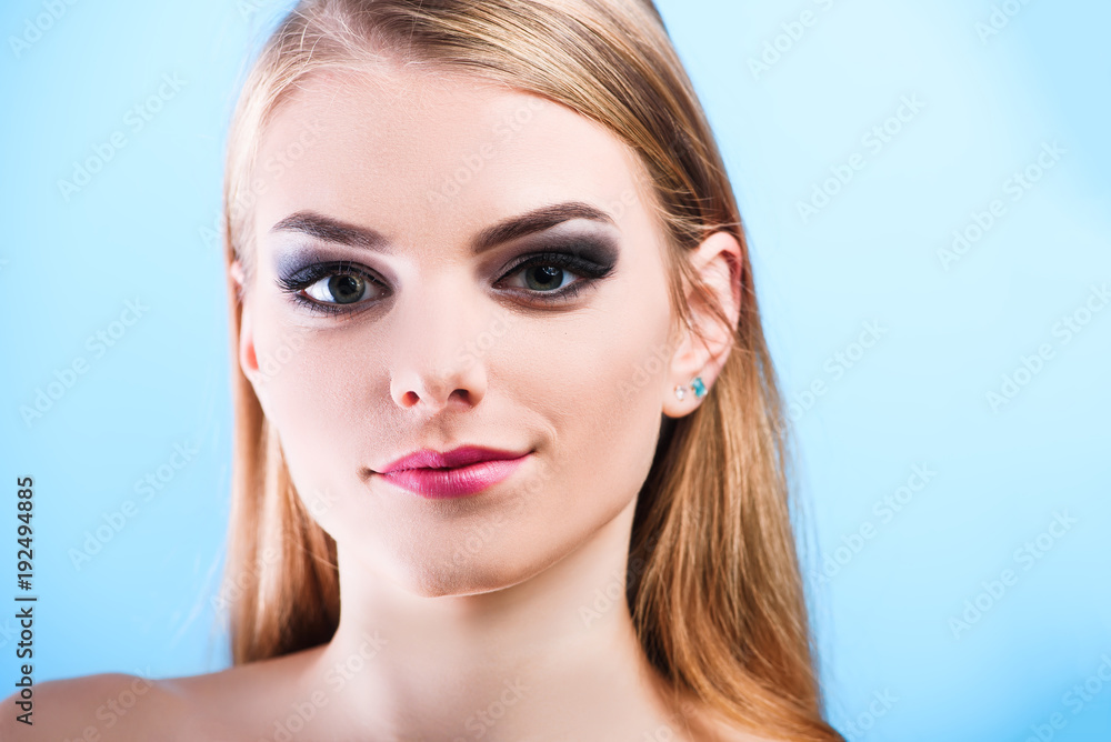 Fototapeta premium Portrait of beautiful female model on blue background