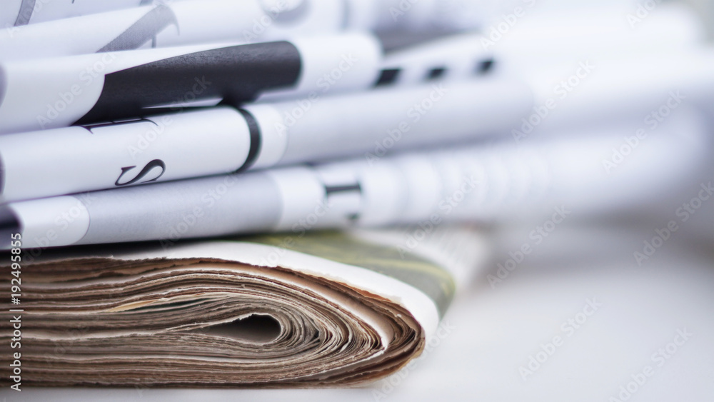 Folded newspapers with headlines observed, selective focus Folded newspapers with headlines observed, selective focus