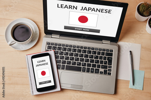 Learn Japanese concept on laptop and smartphone screen over wooden table. All screen content is designed by me. Flat lay