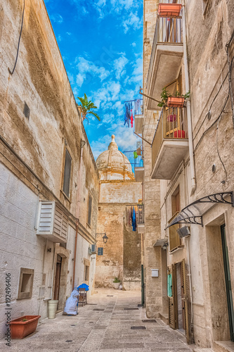 Alleyway in old town Monopoli with the S. Teresa's church in the background, Puglia, Italy