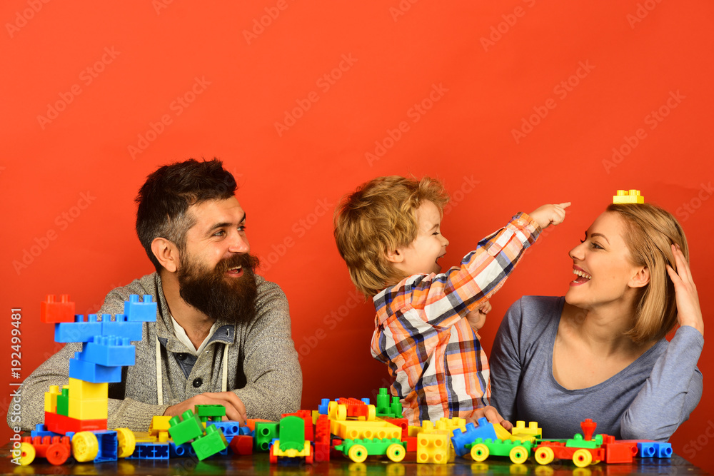 Parents and kid in playroom. Parenthood and game concept Parents and kid in playroom. Parenthood and game concept