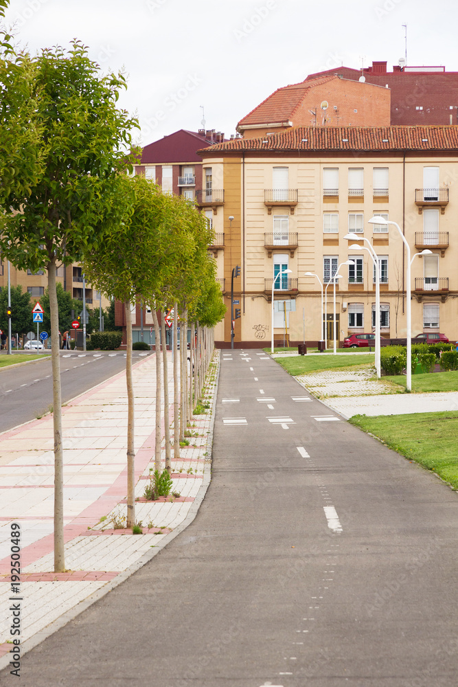 Carril bici de una ciudad con dos direcciones, en paralelo a la avenida y con edificios, arboles y farolas Carril bici de una ciudad con dos direcciones, en paralelo a la avenida y con edificios, arboles y farolas