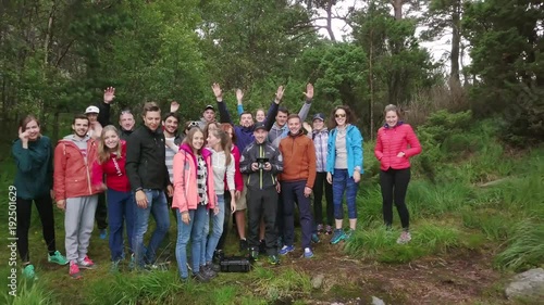 Aerial view on group of young people standing next to the lake and road, they took a brake and the drone is flying away from them. Breathtaking panorama opens. 4k footage. Norway.