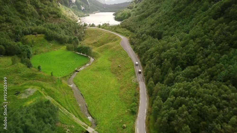 Aerial view on on the cars which are moving by breathtaking mountain road in Norway. Top view, green background full in trees and grass. 4k footage. Aerial view on on the cars which are moving by breathtaking mountain road in Norway. Top view, green background full in trees and grass. 4k footage.