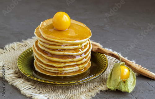 Pancakes with ground-cherry on gray background.