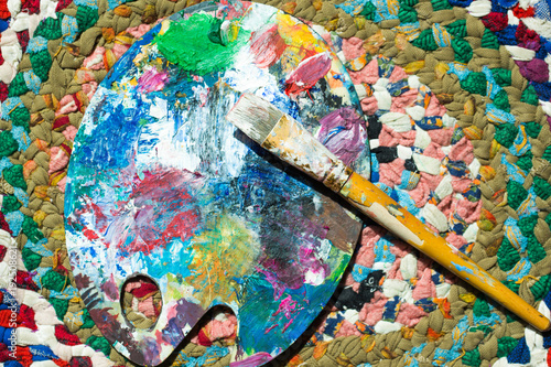 Palette and brush, colorful paints, powder on abstract background