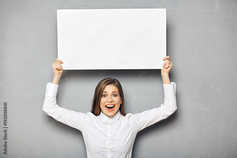 Smiling business woman holding raised up empty white sign board. Smiling business woman holding raised up empty white sign board.