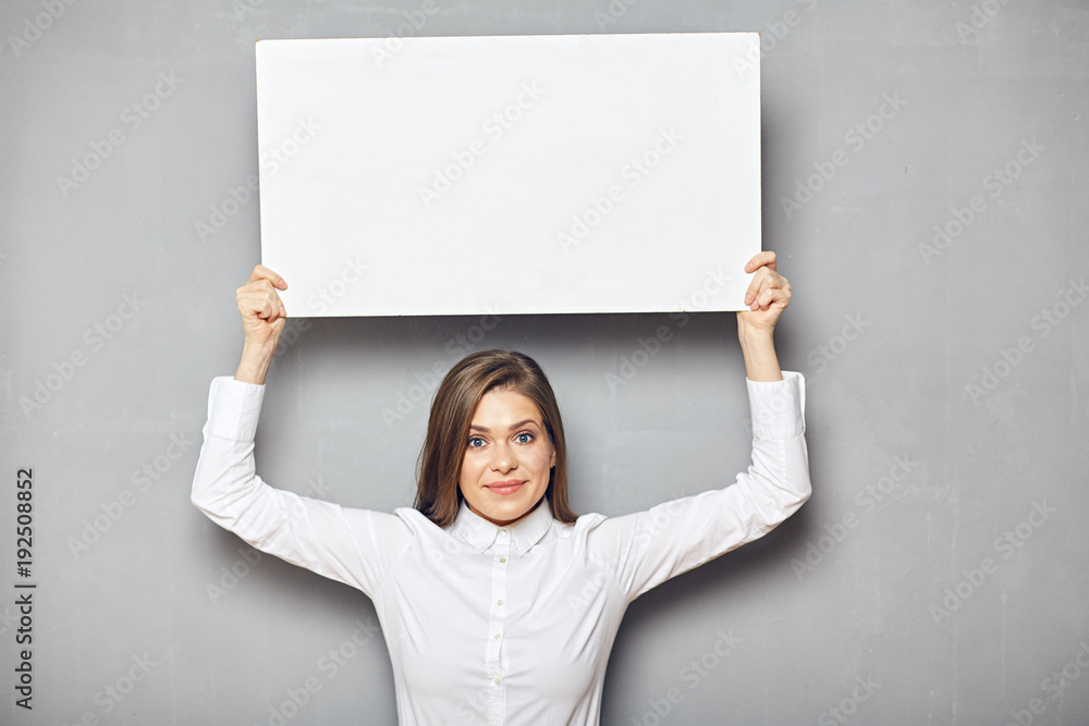 Smiling business woman holding raised up empty white sign board. Smiling business woman holding raised up empty white sign board.