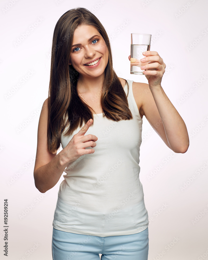Smiling young woman holding water glass and pointing finger. Smiling young woman holding water glass and pointing finger.