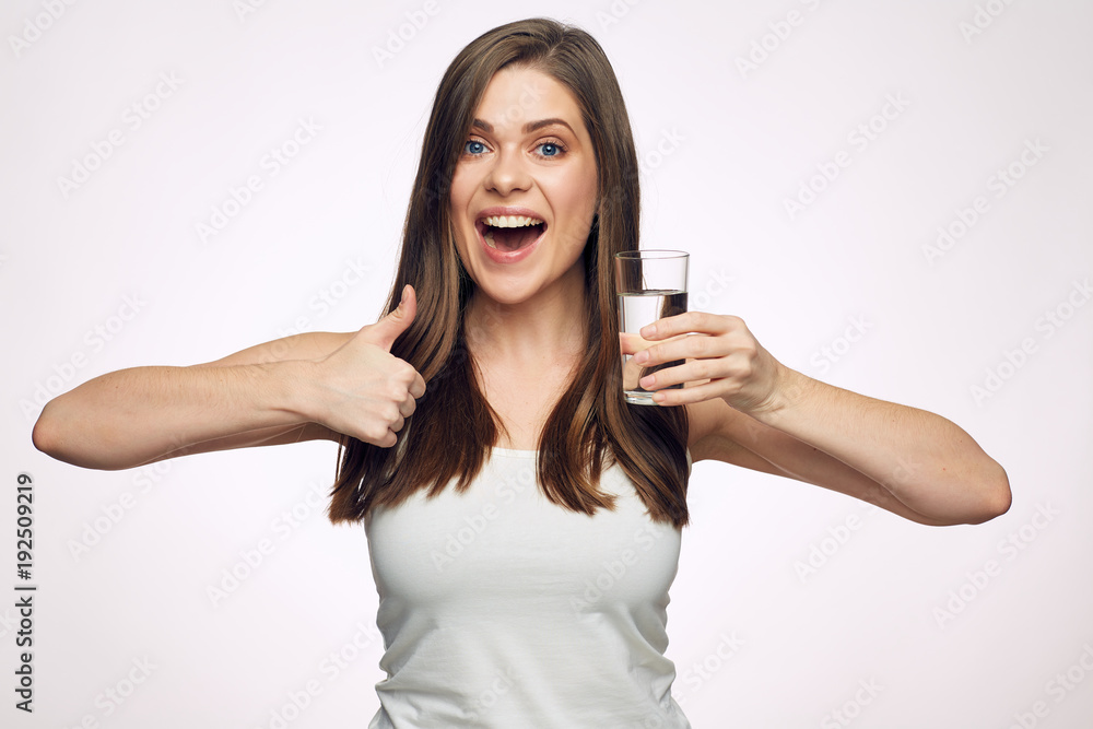 Smiling woman holding water glass showing thumb up. Smiling woman holding water glass showing thumb up.