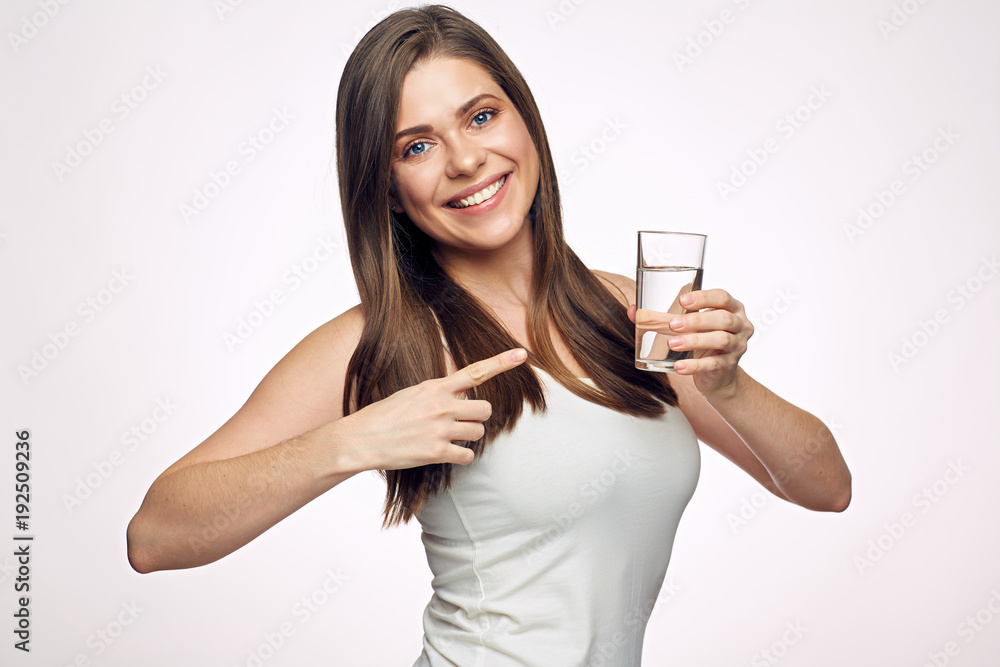 Smiling young woman holding water glass and pointing finger. Smiling young woman holding water glass and pointing finger.