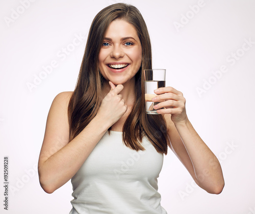 Woman with big toothy smile holding water glass.