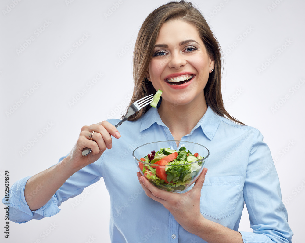 Smiling woman eating salad from glass bowl. Smiling woman eating salad from glass bowl.